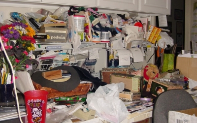 A messy table with piles of crafting supplies in no organized fashion