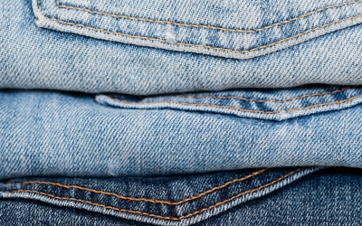 An extreme close up of folded jeans in light and dark shades.