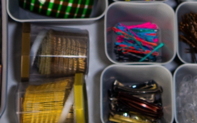 Plastic containers holding small and similar items in each -- plastic sewing needles, pins, and other small objects.